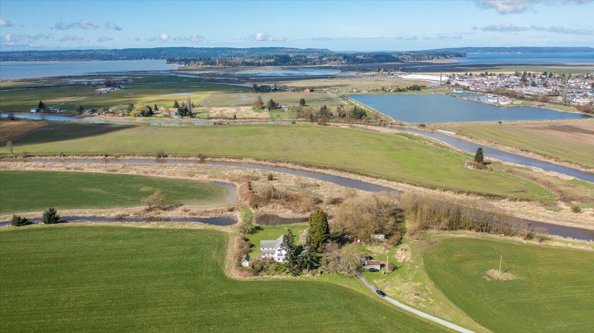 Aerial view westward from a Camano Island area property toward Puget Sound — pastoral land with mountain views